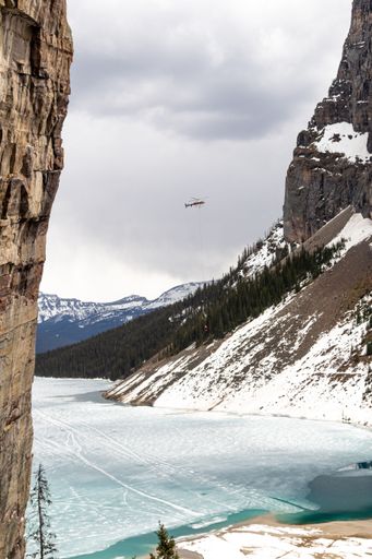 A vertical shot of a helicopter conducting a rescue near the frozen Lake Louise in Alberta, Canada
