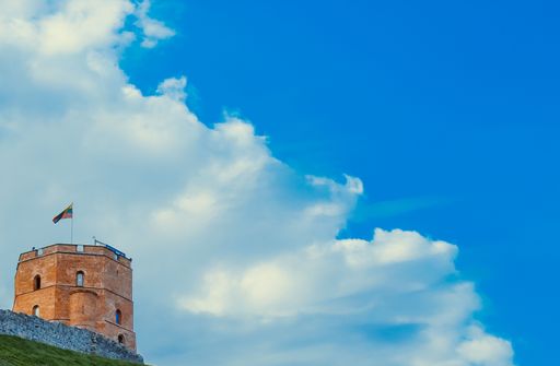 A low angle shot of a stone tower under a blue sky in Vilnius, Lithuania