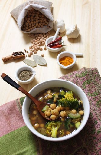 Garbanzo Beans With Zucchini and Broccoli With Spices on Rustic Wooden Table