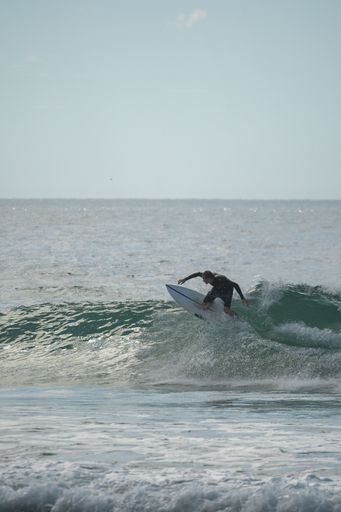 A vertical shot of surfer riding surfboard in ocean