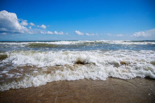 Ocean foamy waves washing the sandy shore