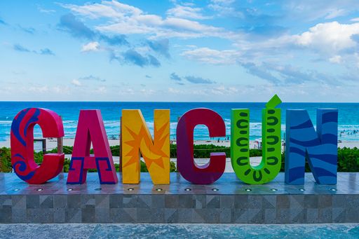 A closeup shot of the colorful word Cancun on the seashore on a bright day in Mexico