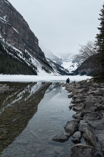 A vertical shot of the frozen lake near snowy mountains in Jasper, Canada