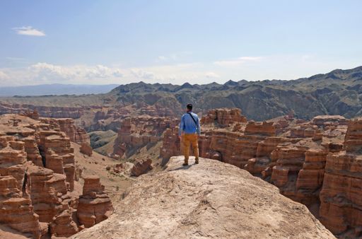 Man standing on a rock overseeing the magnificent landscape of Charyn Canyon
