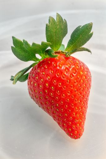 A vertical shot of the top view of delicious and fresh strawberry in a plate