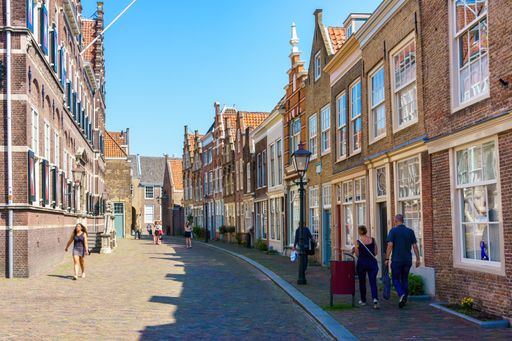 Old street in Middelburg, Zeeland, The Netherlands. People walking on a sunny day in spring