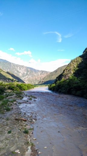 A vertical shot of the river surrounded by mountains.