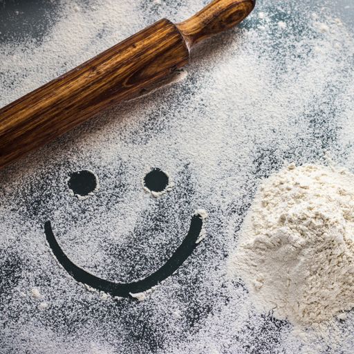 A top view of a smiling face pictured on sprinkled flour