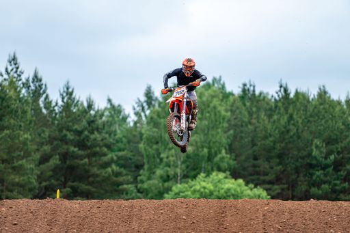 The racer on motocross in flight at the "Donkey of the road" at Latvian National Motocross Cup in Dobele