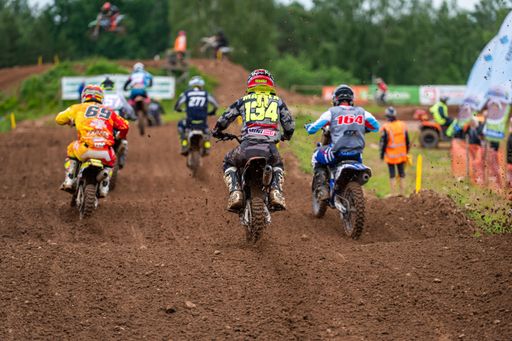 Competitive motorbikers riding during Latvian National Motocross Cup on a soil ground