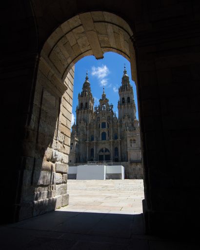 A vertical shot of the Cathedral of Santiago de Compostela located in Santiago, Spain through an arch