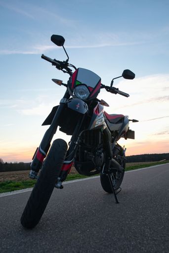 Aprilia SX 125 is standing on a road