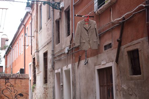 An old beige jacket hanging on the street in the old town of Venice
