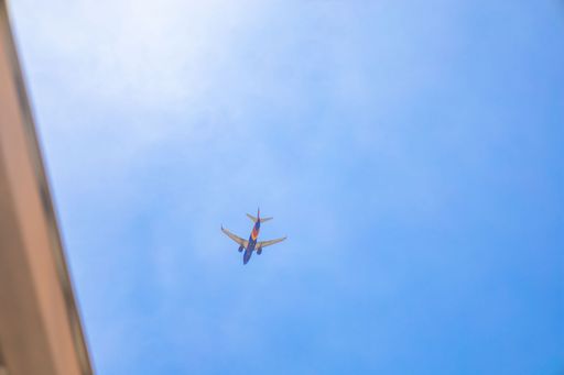 A low angle shot of a passenger plane flying in blue sky