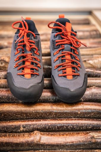 Close up product photo of a pair of trekking or hiking shoes on wooden back ground. Outdoor boots product photo.