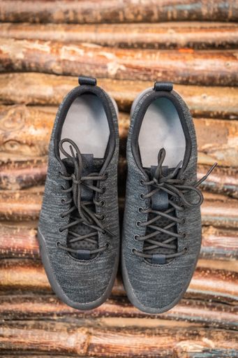 Close up product photo of a pair of trekking or hiking shoes on wooden back ground. Outdoor boots product photo.