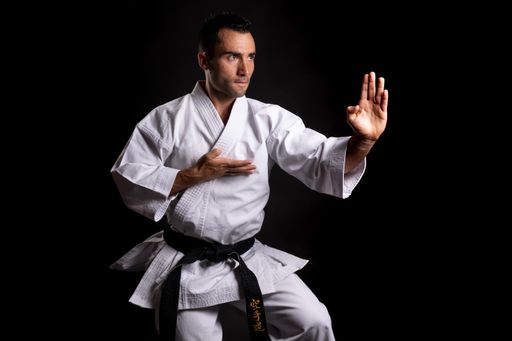 A closeup shot of a male practicing Asian martial arts on a black background