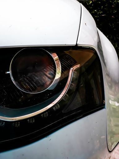 The black  headlight of a luxury white car