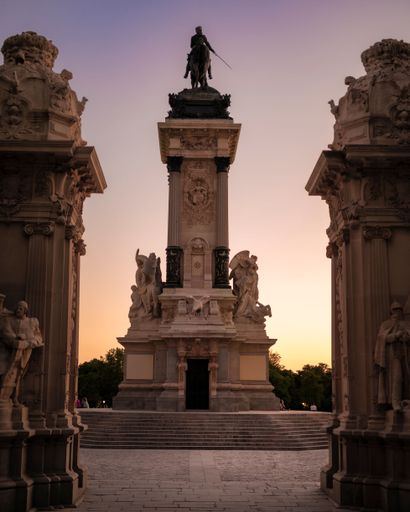 A vertical shot of the statues in the Parque del Retiro in Madrid at sunset