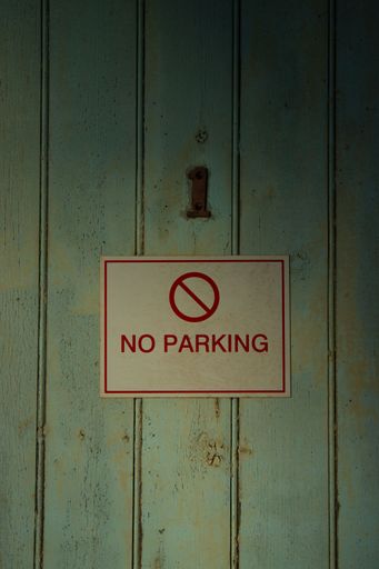 A closeup of No Parking sign on an old door