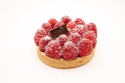 A cookie with raspberries and a piece of chocolate bar isolated on the white background
