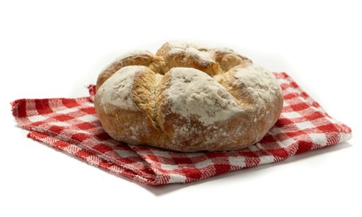 A fresh baked bread on the red checkered towel isolated on white background