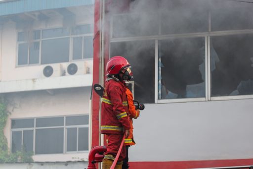 A closeup of a firefighter extinguishing the fire of the Padang restaurant in Tangerang, Indonesia