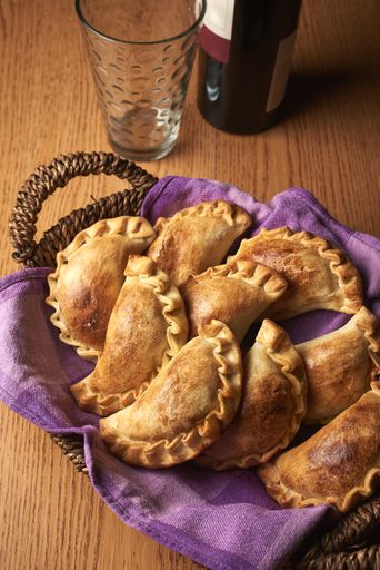 An vertical shot of a basket with freshly baked pastries laid on a purple napkin