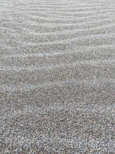 A vertical shot of sand creating wave patterns