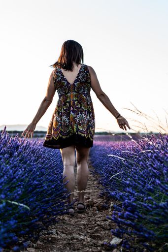 A vertical shot of a female walking on a lavender field captured in Brihuega, Spain