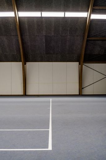 A vertical shot of an indoor basketball court with symmetrical patterns