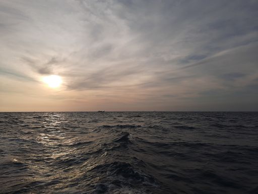 The beautiful wavy ocean gleaming under the cloudy sky