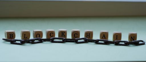 The word 'Blockchain' made with wooden letter beads put on a white surface
