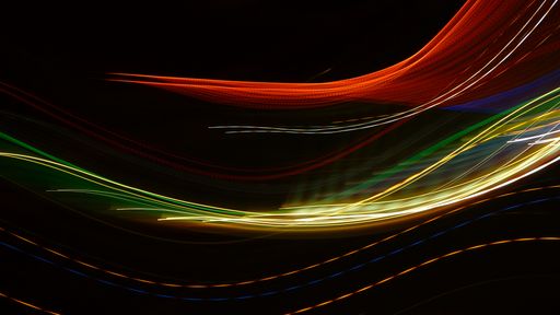 A closeup of colorful light trails on a dark background - great for wallpapers