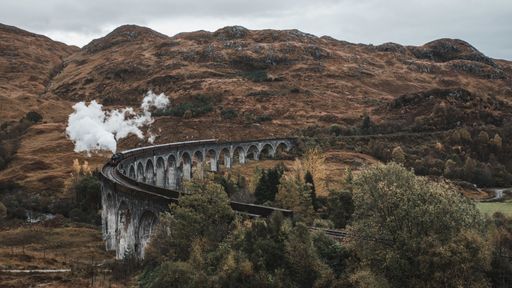 A high angle shot of the famous historical Steam Train in Glenfinnan viaduct, Scotland