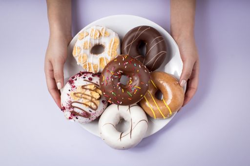 An overhead shot of different types of tasty donuts on a white background