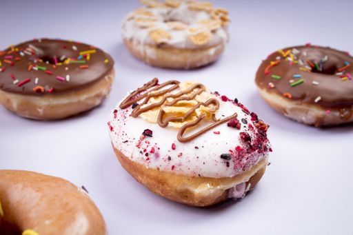 A high angle shot of different types of tasty donuts on a white background