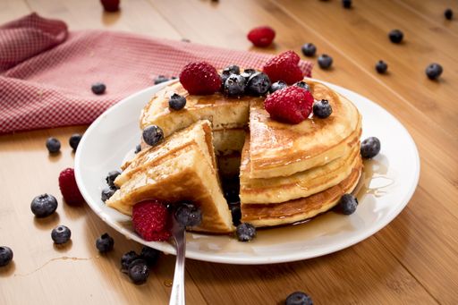 A closeup shot of freshly baked pancakes with fresh berries on top
