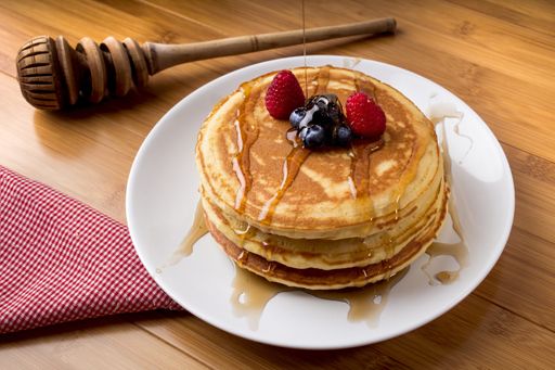 A closeup shot of freshly baked pancakes with fresh berries on top