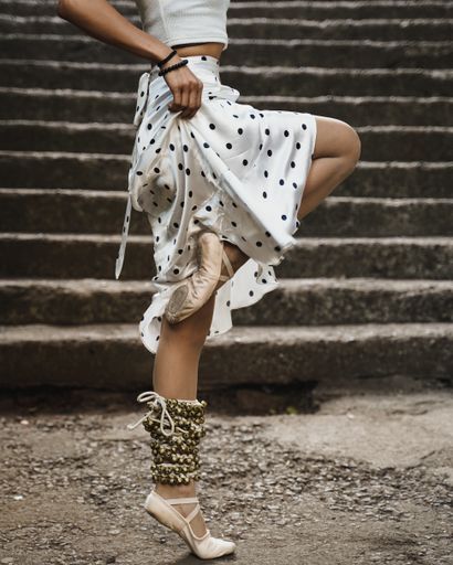 A closeup shot of a ballet dancer dancing in the street