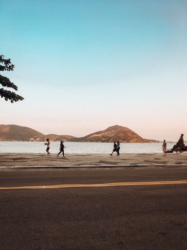 Vertical shot of people exercising during covid times in Rio de Janeiro beach.