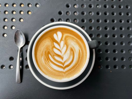 A closeup of a cup of coffee with a beautiful pattern on the surface. Latte art.