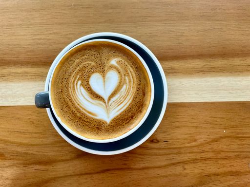 A closeup of a cup of coffee with a beautiful pattern on the surface. Latte art.