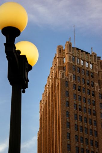 A vertical low-angle shot of a streetlight and a high-rise building