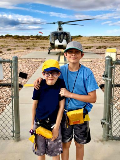 A portrait of two male children standing on a pathway with a chopper behind them