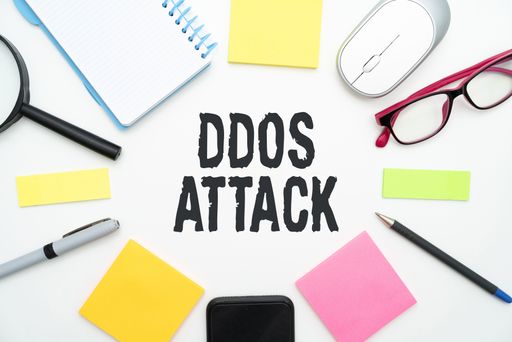 A colorful illustration of a phone, glasses, office supplies with ddos attack text in the middle