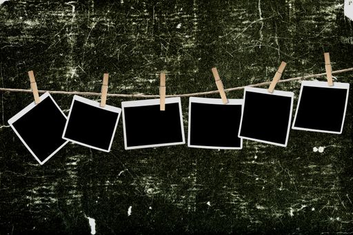 A vintage wall with blank instant pictures hanging from a rope
