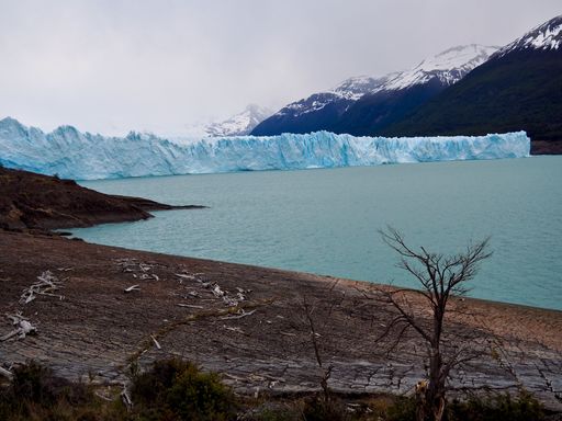 A view of the Perito Moreno glacier in Argentina on a cloudy day, mountains in the background