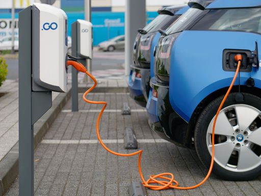 A closeup of blue electric car charging in station
