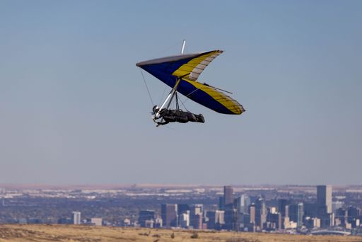 A scenic view of a hang glider high in the blue sky